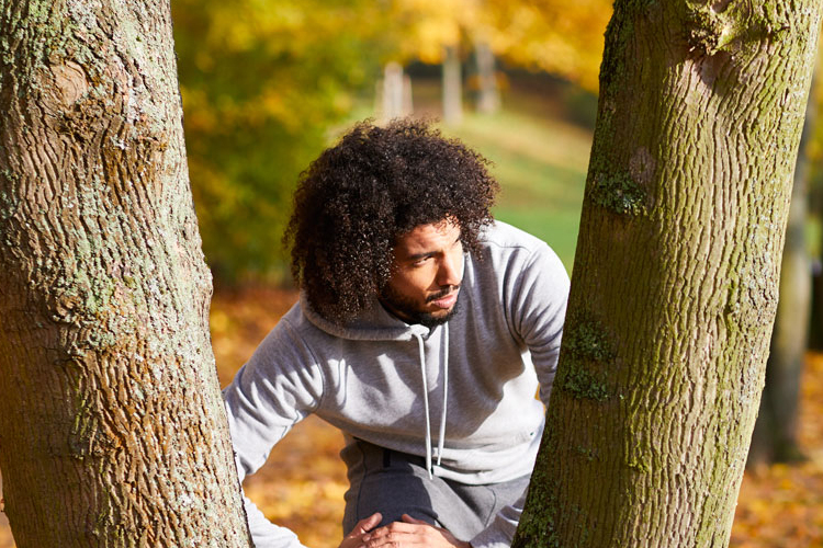 Mann im Herbst am Baum