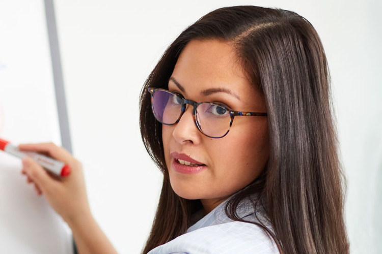 Frau mit Brille am Whiteboard