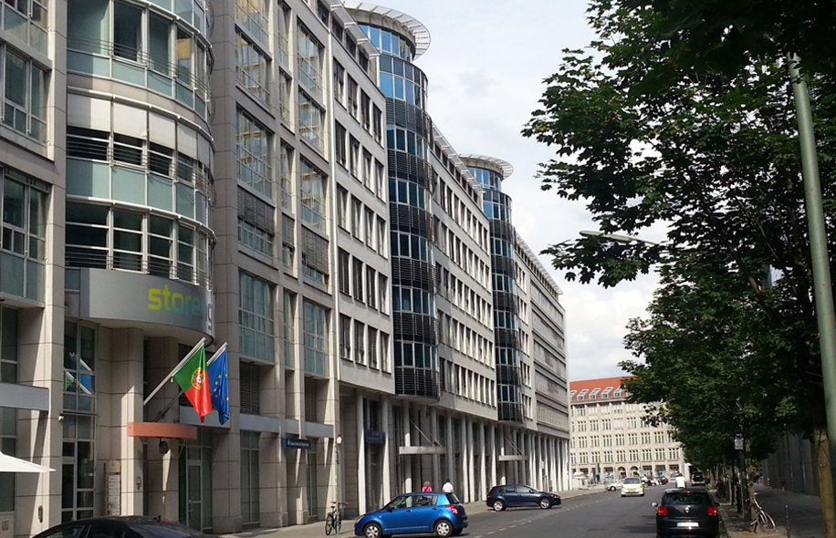 Ein Hochhaus und eine befahrene Straße im Vordergrund. 